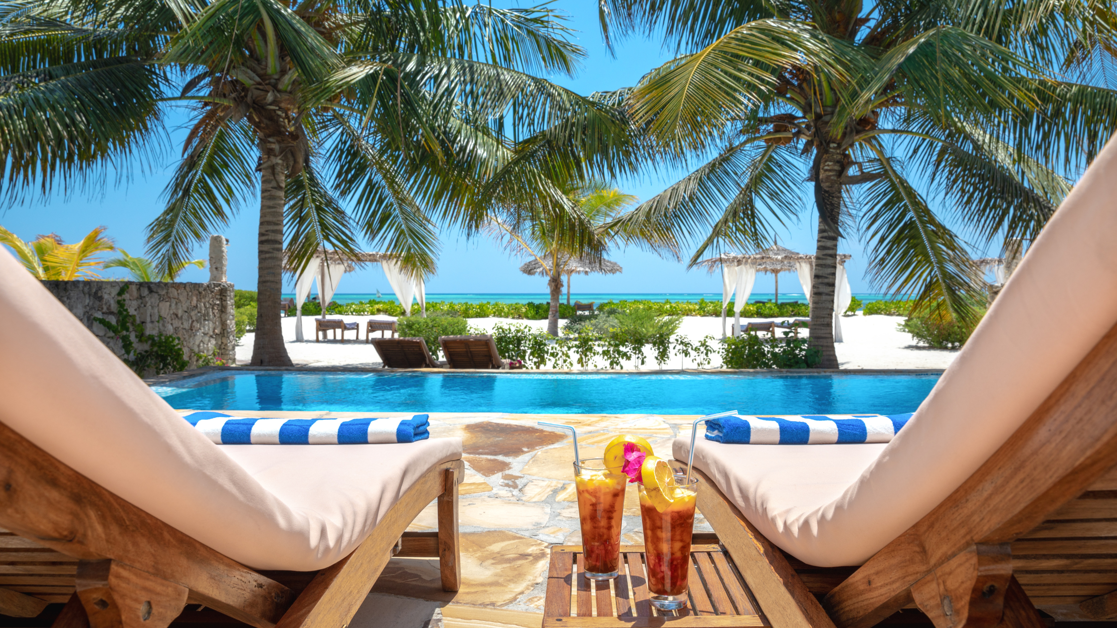 a pair of deckchairs by a swimming pool.